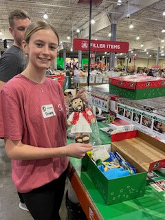 Workers at the Operation Christmas Child Processing Center in Boone, NC.  are packing The Shoebox Jesus Doll into shoeboxes to be distributed to children around the world. 